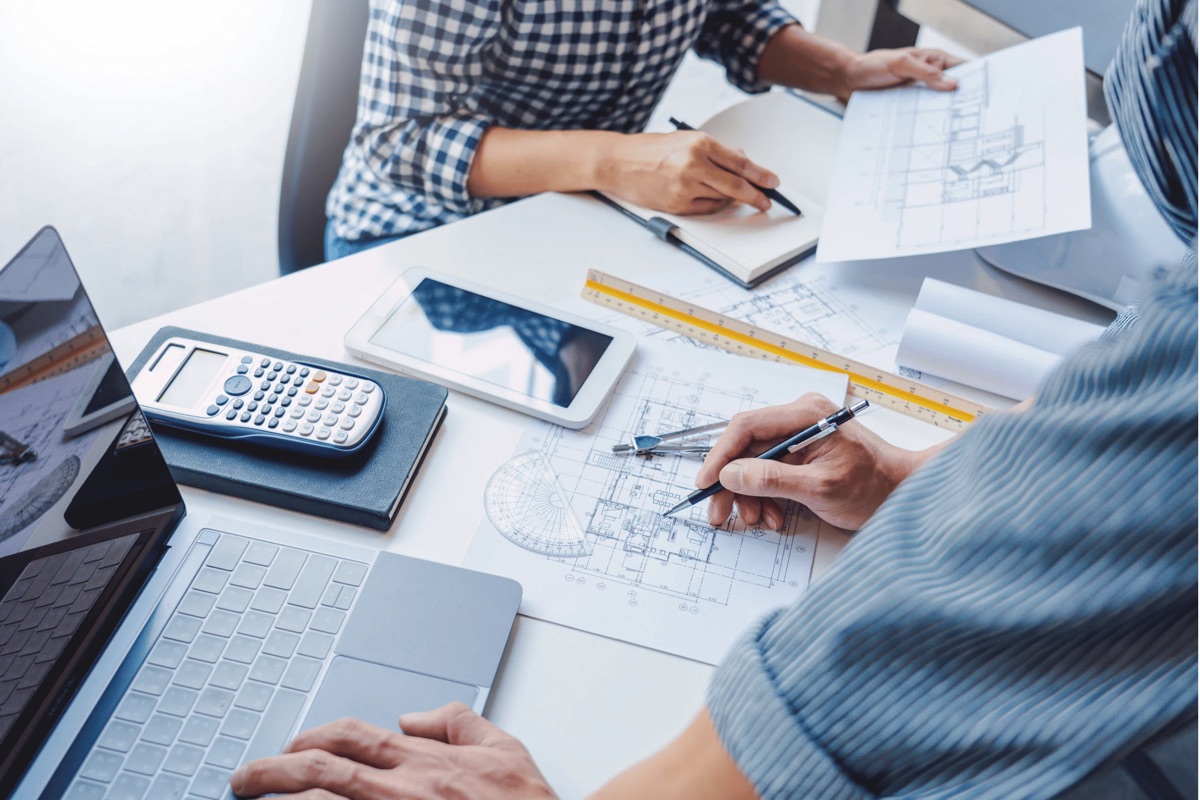 Moon-Matz engineers working at desk with blueprints